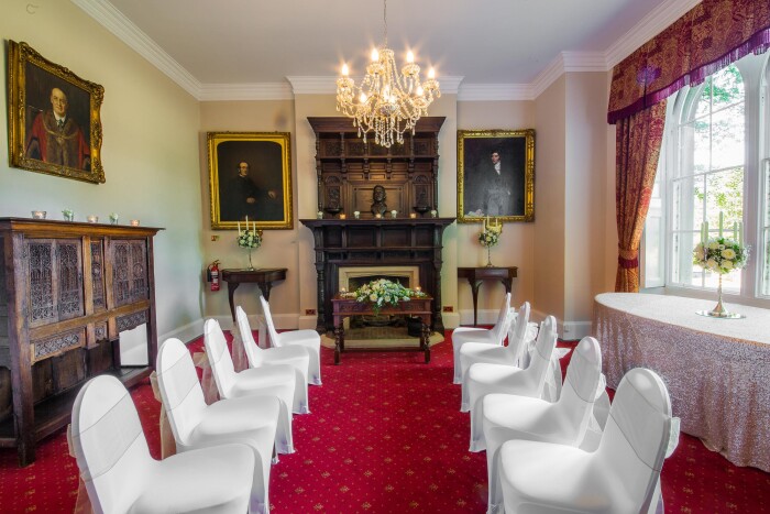 The Mayors Parlour set up for a wedding ceremony, the chairs covered white chair covers with gold bows,