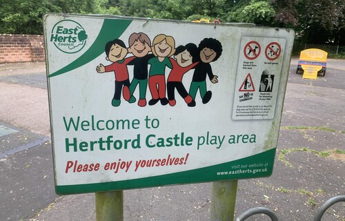 Signage from the Hertford Castle play area, with an illustration on children in the center. 